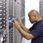 STRATO Mitarbeiter hebt einen Server zurück in ein Rack